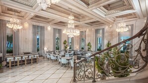 A grand lobby with a marble floor, elegant chandeliers, and a staircase with ornate railings. - The Plaza, A Fairmont Hotel (New York)