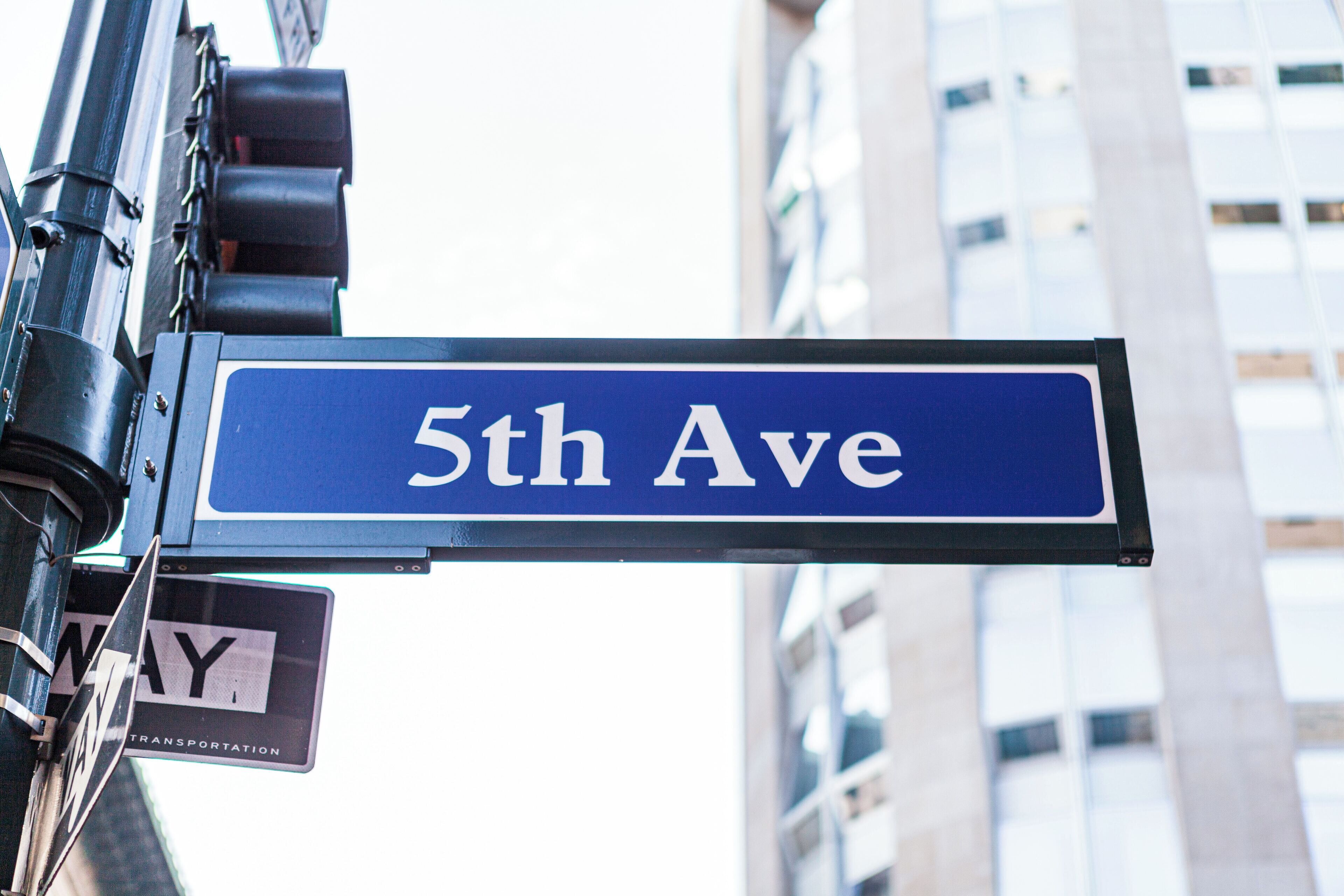 A street sign for "5th Ave" with a "One Way" sign below it, mounted on a pole.