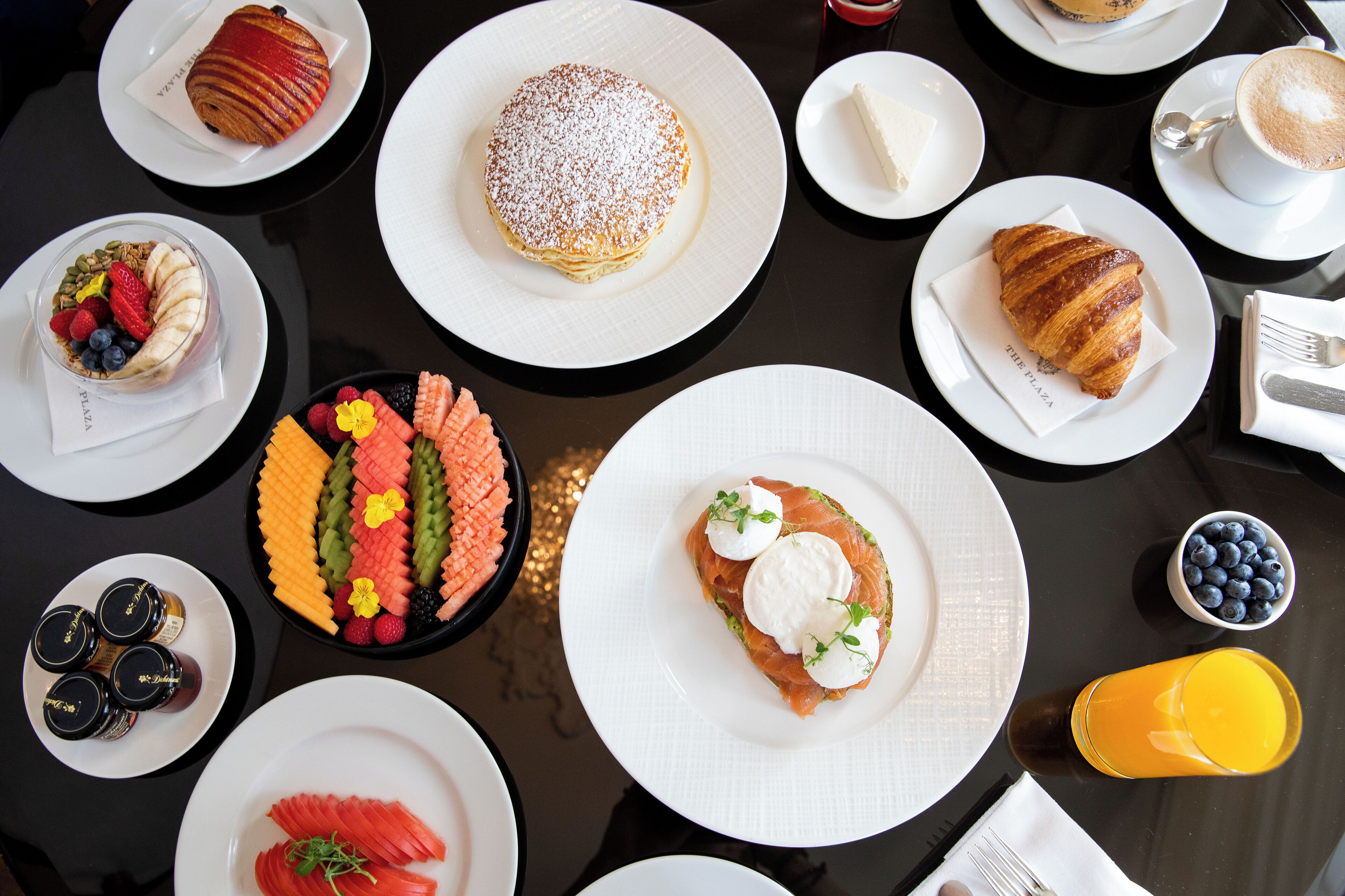 A table with various breakfast items including pastries, fruits, and beverages.