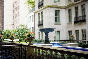 A luxurious living room with a grand fireplace, elegant furniture, and a large mirror. at The Plaza, A Fairmont Hotel