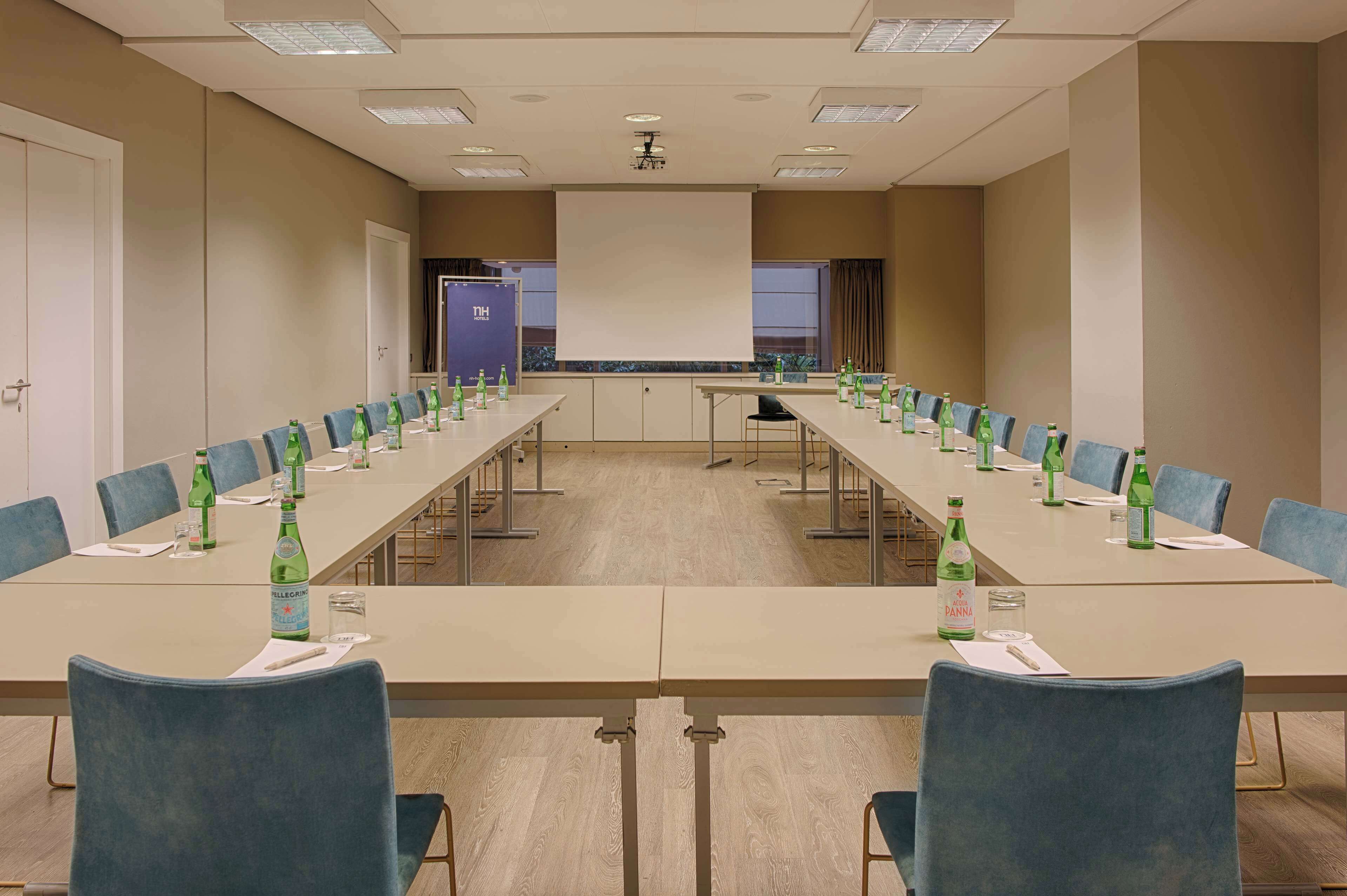 A conference room with a long table, chairs, and bottles of water.