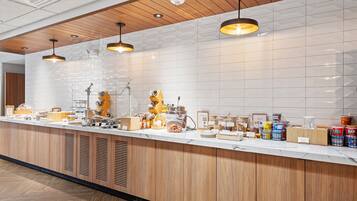 A breakfast bar with wooden cabinets, white tiled backsplash, and pendant lighting.