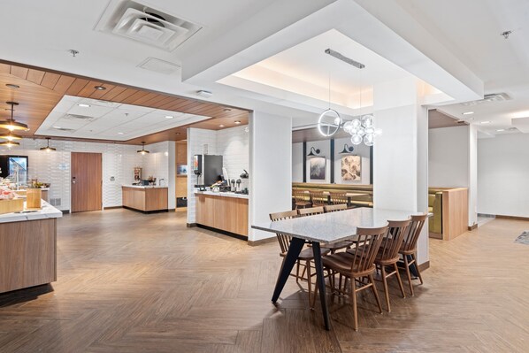 A spacious, modern kitchen with wooden cabinetry, a central island, and pendant lighting.