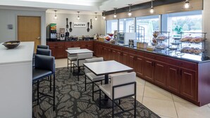 A modern kitchen with a breakfast bar, seating area, and large windows. - Wingate by Wyndham Shreveport Airport (Shreveport)