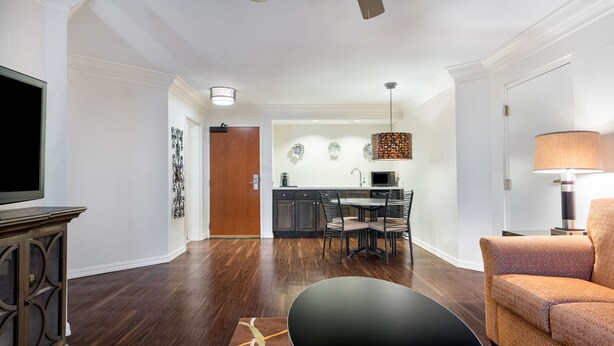 A modern living room with a flat-screen TV, a black coffee table, and a patterned sofa. - Holiday Inn Fort Lauderdale Airport by IHG (Hollywood)