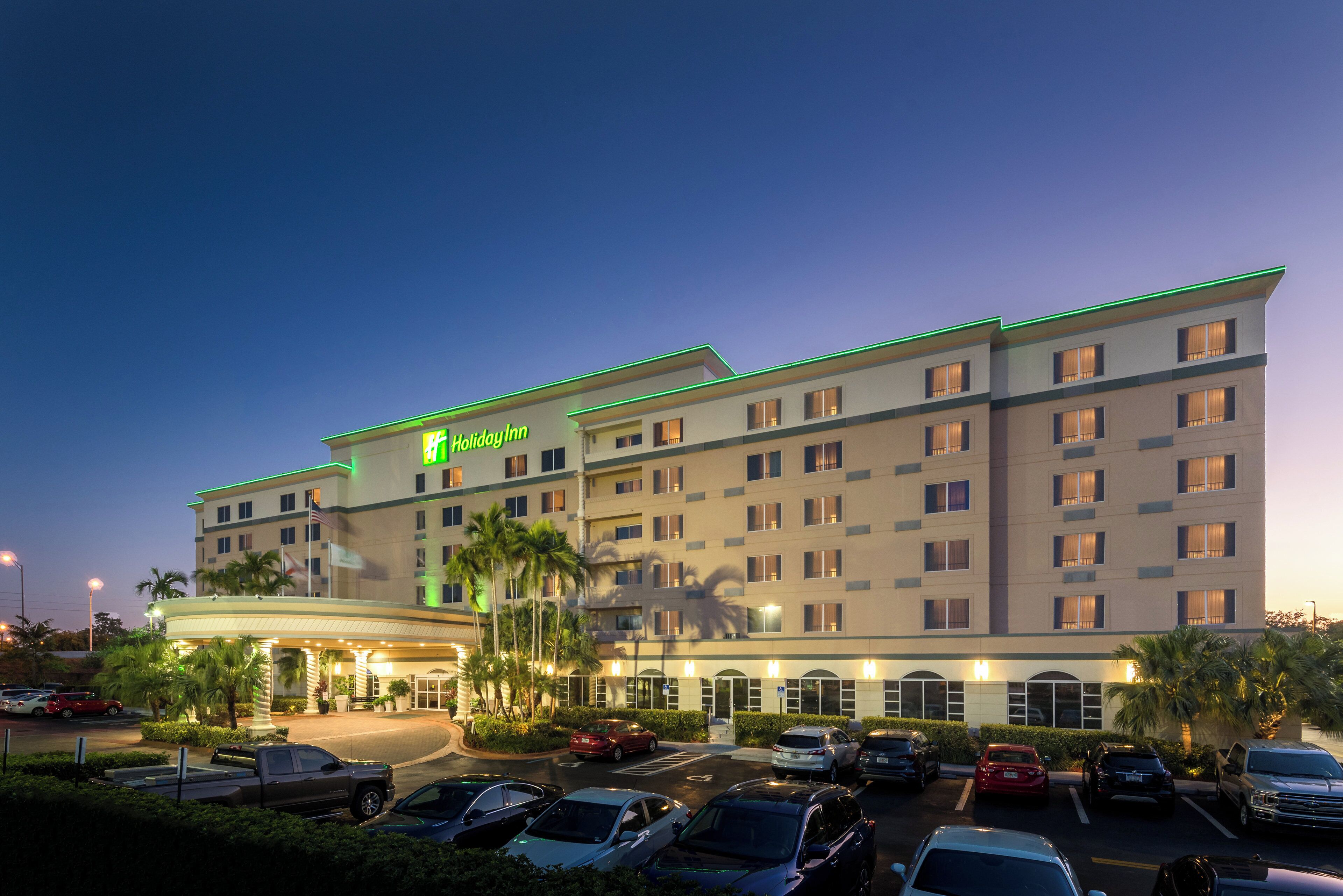 A multi-story Holiday Inn hotel with a parking lot in front.