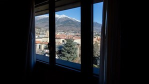 A view from a window overlooking a town with a mountain in the background.