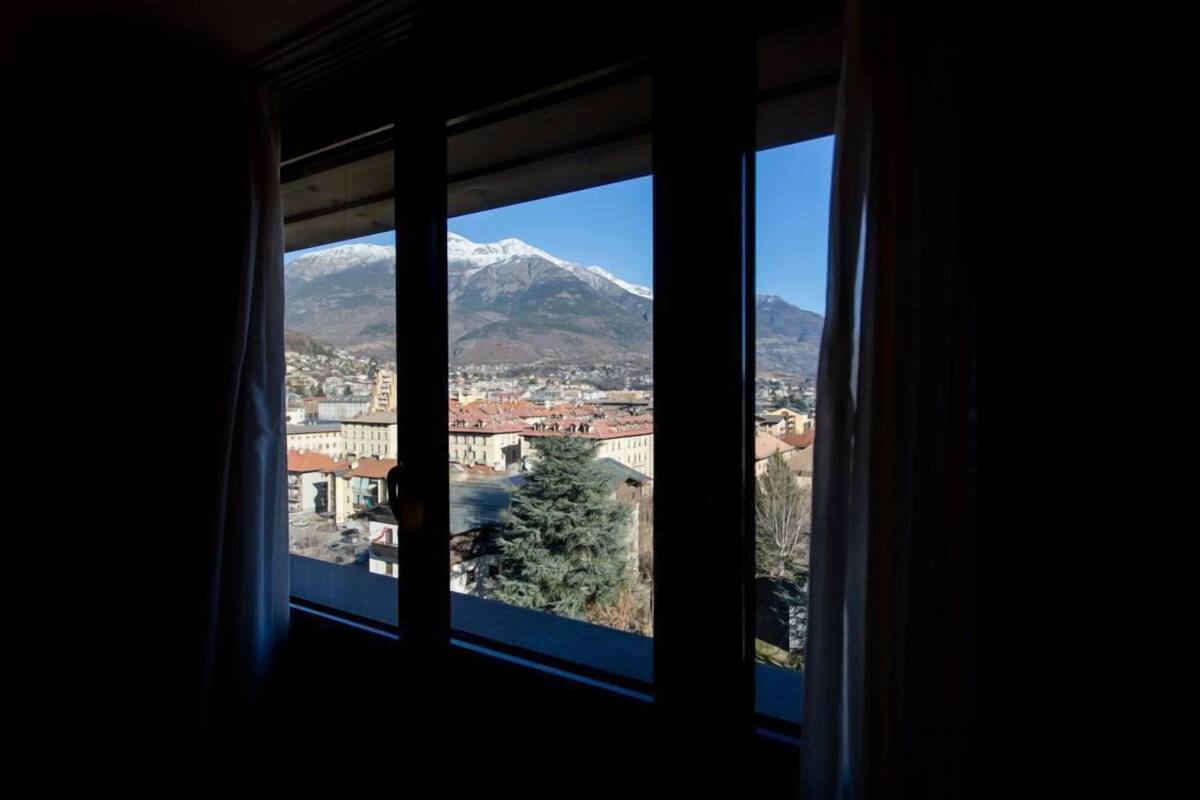 Vista dalla finestra su una città con una montagna sullo sfondo.