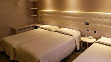 A hotel room with a large bed, bedside tables, and a small round table.