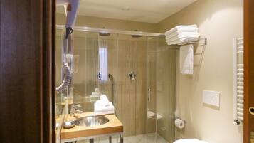 A modern bathroom with a glass-enclosed shower, a wooden vanity with a sink, and a toilet.