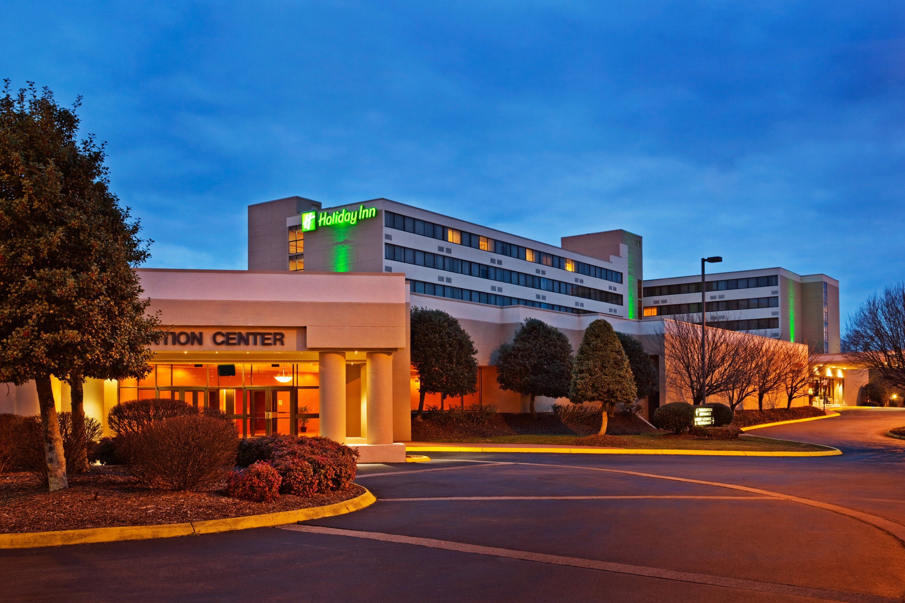 A Holiday Inn Express hotel with a modern design, featuring a prominent entrance and a well-lit facade.
