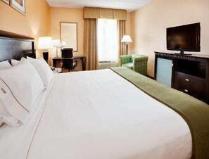 A hotel room with a large bed, a desk, a chair, a television, and a window with curtains. - Baymont by Wyndham East Windsor Bradley Airport (East Windsor)