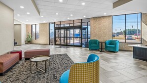 A spacious lobby with a modern design, featuring a mix of seating options, a reception desk, and large windows offering views of the outside. - Sonesta Select Hotels Statesville (Statesville)