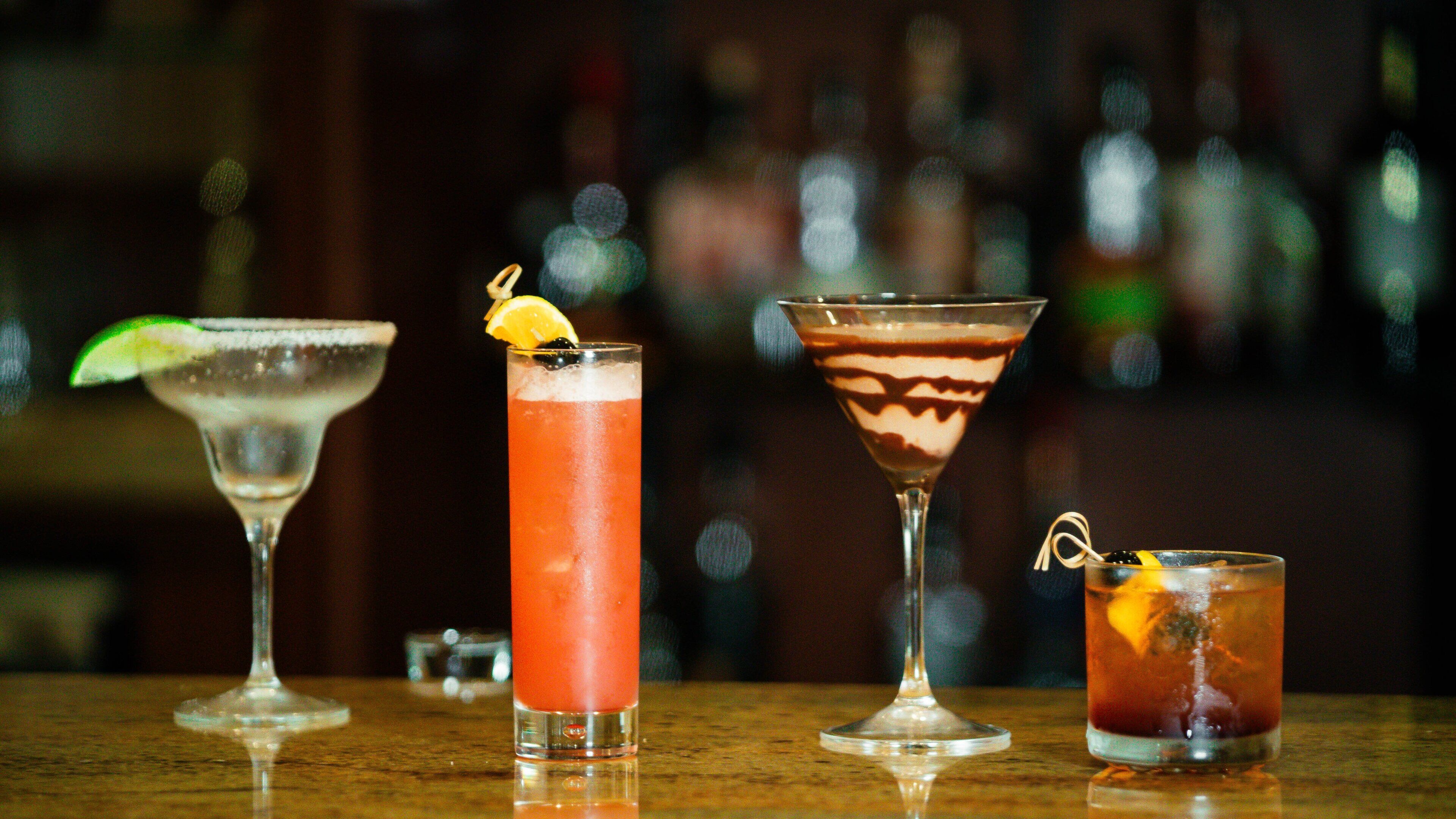 Three different cocktails on a bar counter.