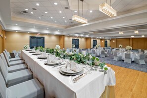 A banquet hall with long tables set for a formal event, featuring white tablecloths, silverware, and floral centerpieces. - Crowne Plaza Houston Med Ctr-Galleria Area by IHG (Houston)
