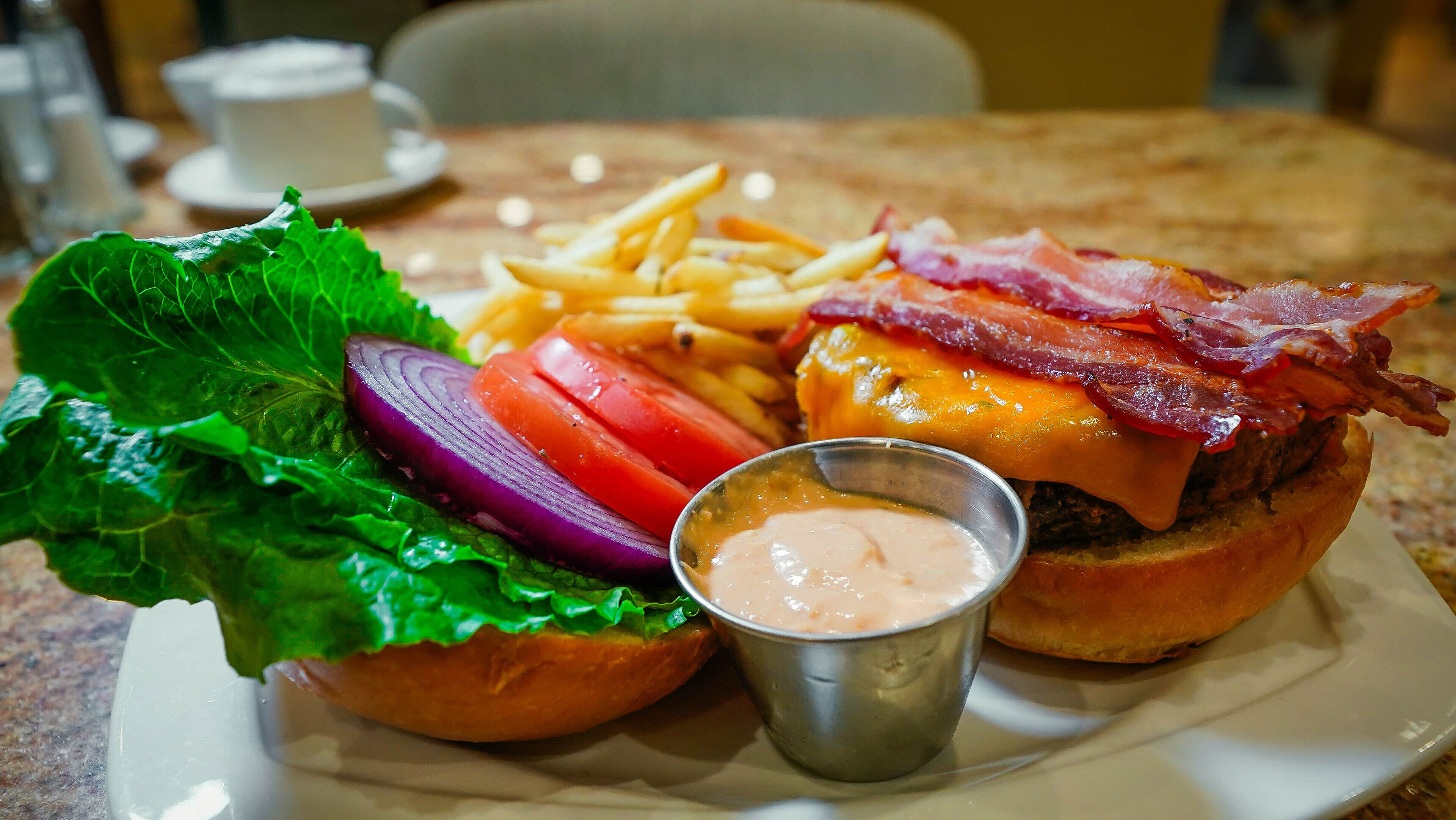 A plate with a burger, fries, and a side salad.
