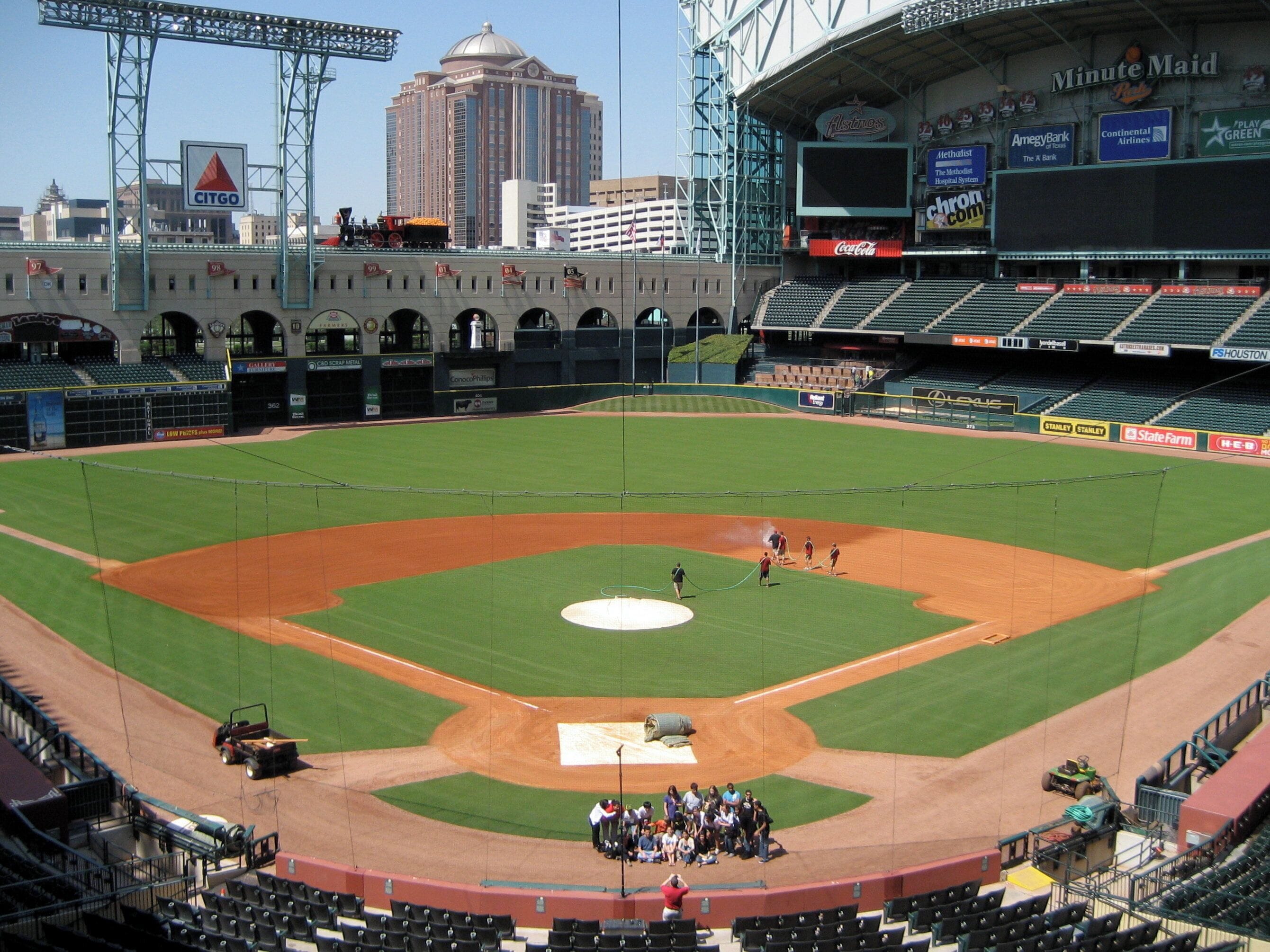 A baseball stadium with a large field, seating areas, and a scoreboard.