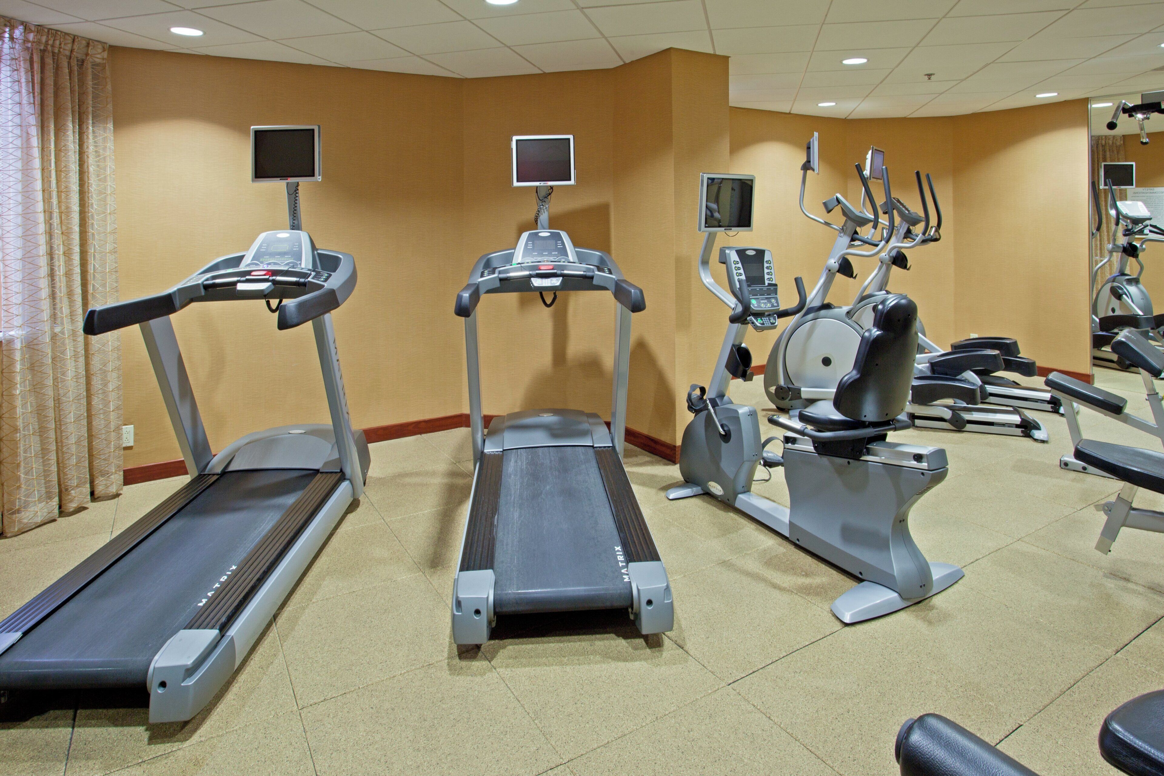 A fitness center with treadmills, elliptical machines, and stationary bikes.