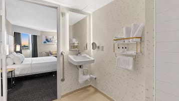 Une chambre d’hôtel avec un lit, une salle de bain avec un lavabo et un porte-serviettes.