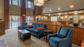 A lobby with a bar area, seating with blue sofas and ottomans, and large windows. - Comfort Inn & Suites Springfield I-44 (Springfield)