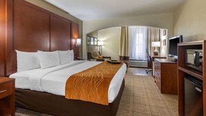 A hotel room with a large bed, a desk with a computer, a TV, and a minibar. - Comfort Inn & Suites Springfield I-44 (Springfield)