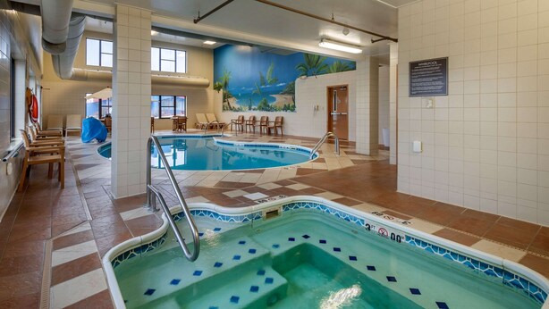 An indoor swimming pool with multiple lanes, lounge chairs, and a mural of a beach scene on the wall. - Comfort Inn & Suites Springfield I-44 (Springfield)