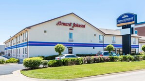 A Howard Johnson Inn building with a sign, a parking lot, and well-maintained landscaping. - Howard Johnson by Wyndham Wichita Airport (Wichita)