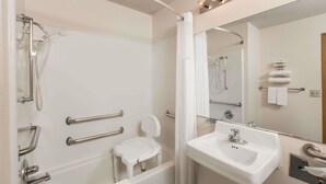 A modern bathroom with a bathtub, shower, and a sink. - Howard Johnson by Wyndham Wichita Airport (Wichita)