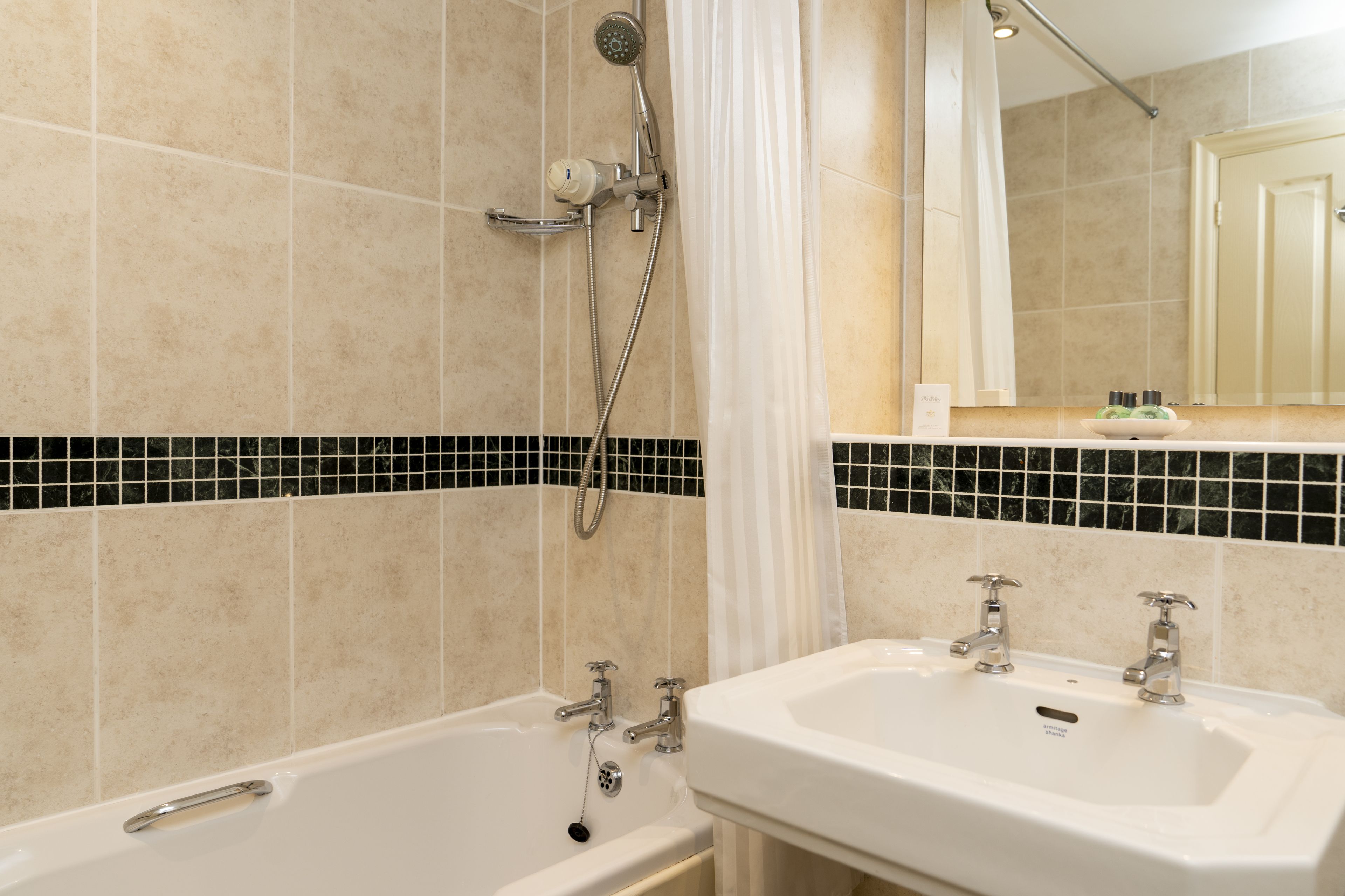 A bathroom with a bathtub, two sinks, a shower, and a tiled backsplash.
