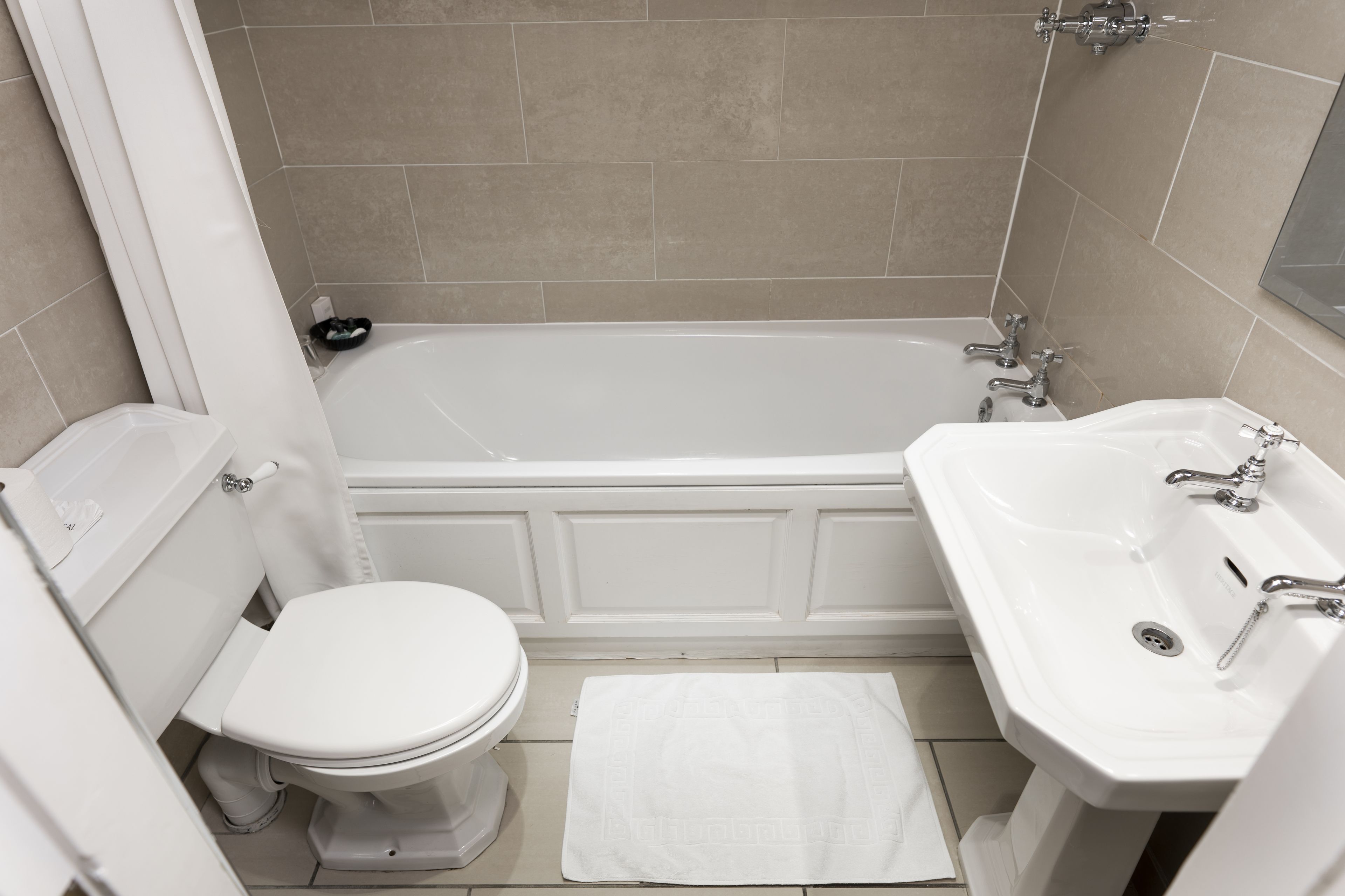 Un bagno con vasca, water e lavandino.