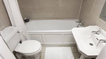 Un bagno con vasca, water e lavandino.