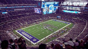 A large stadium with multiple levels of seating, a football field, and a large screen displaying an event. - Crowne Plaza Dallas Market Ctr - Love Field by IHG (Dallas)