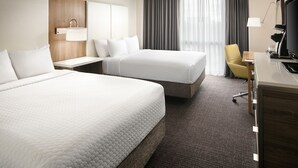 A hotel room with two beds, a desk, a chair, a TV, and a window with curtains. - Crowne Plaza Dallas Market Ctr - Love Field by IHG (Dallas)