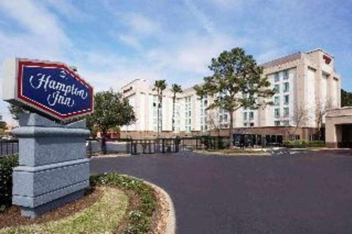 A Hampton Inn sign and a large hotel building with multiple floors and a classic architectural style.