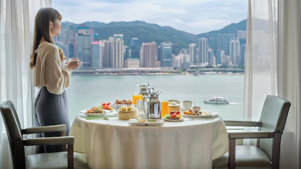 A dining table set with breakfast items and a view of a cityscape through large windows. - InterContinental Grand Stanford Hong Kong by IHG (Kowloon)