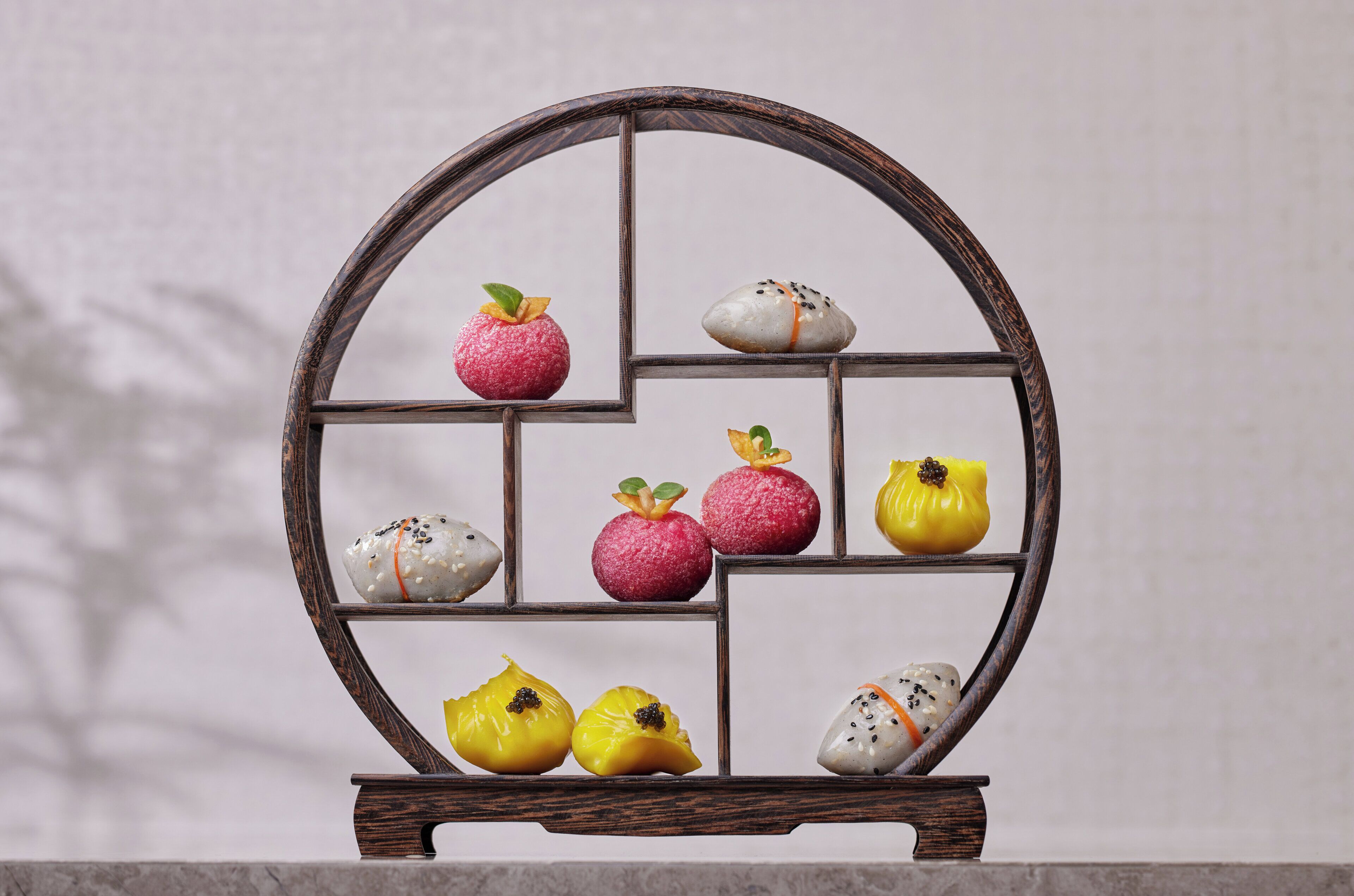 Un expositor de madera con frutas y verduras dispuestas en compartimentos.