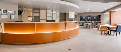A modern reception area with a curved desk, multiple seating options, and a clean, well-lit interior.