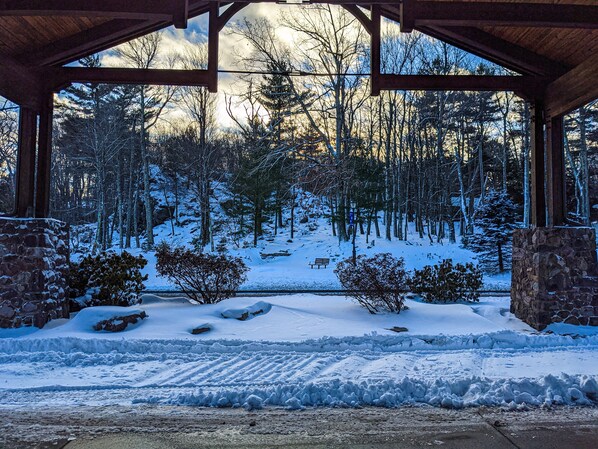 A covered outdoor area with stone walls and a view of a snowy forest.