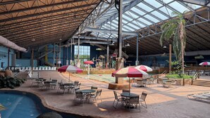 An indoor atrium with a high ceiling, seating areas, and a pool.