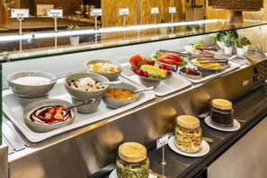 A buffet with various food items and labels.