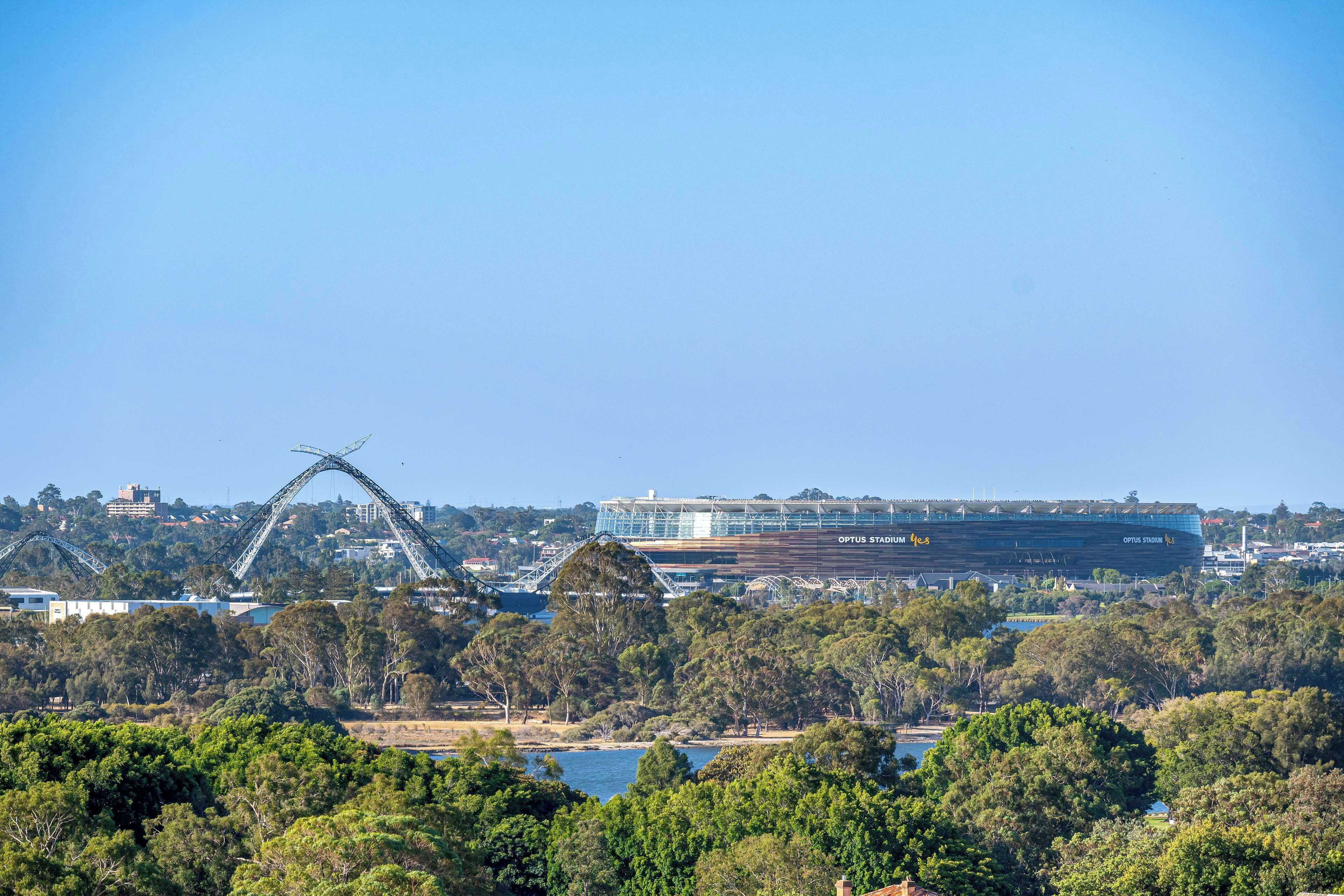 Um estádio com uma estrutura em arco marcante e um grande edifício com a inscrição 