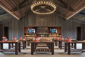A spacious kitchen with modern appliances, wooden tables, and a large overhead light fixture. - Ojai Valley Inn (Ojai)