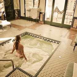 Relax by the pool surrounded by a geometric patterned floor and lounge chairs.