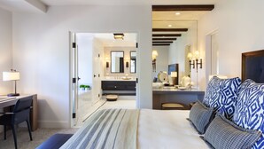 A modern hotel room with a large bed, a desk, and a bathroom visible through an open door. - Ojai Valley Inn (Ojai)