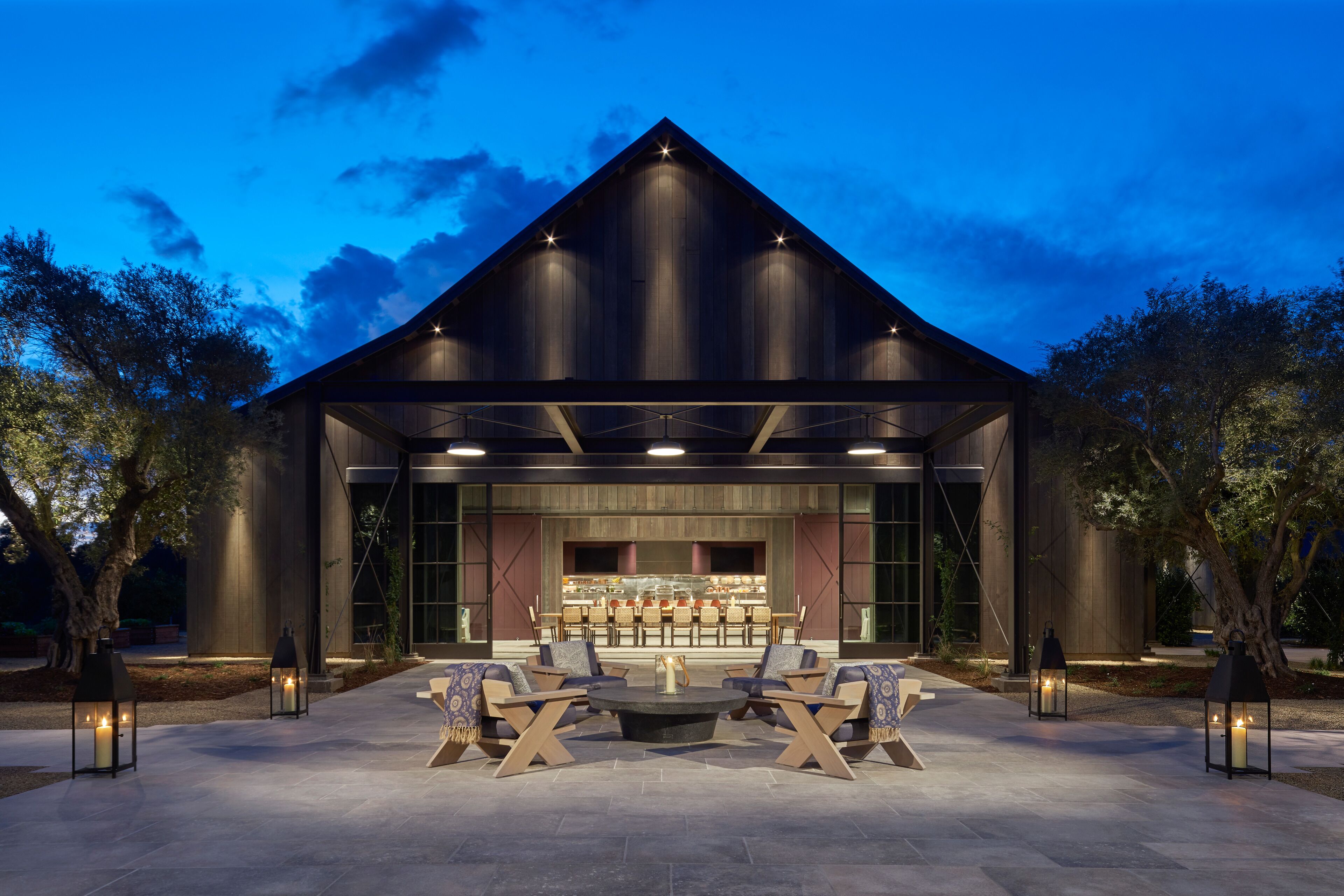 Un bâtiment moderne doté d’un espace repas avec des places assises en plein air et un bar.