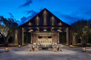 A modern building with a dining area featuring outdoor seating and a bar. - Ojai Valley Inn (Ojai)