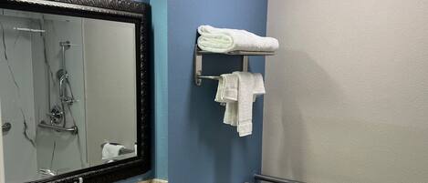 A bathroom with a sink, mirror, toilet, and towel rack.