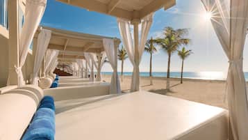On the beach, white sand, beach cabanas, sun loungers