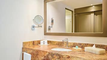 A bathroom with a marble sink, a large mirror, and a towel rack.