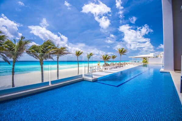 Relax by the ocean with a clear view of the sandy shoreline from this pool area.